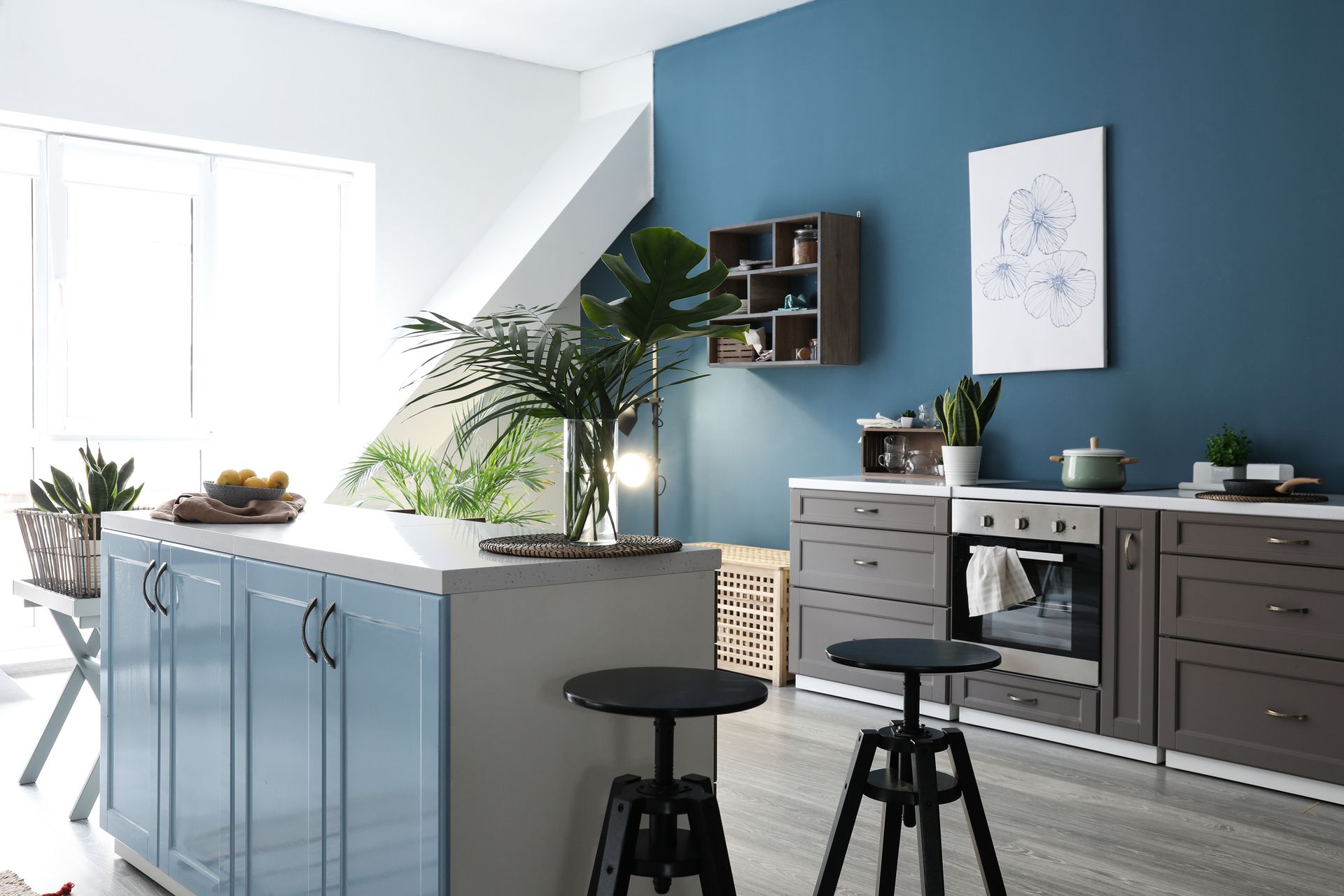 Modern kitchen with blue island, dark cabinets, stools, and bright natural light Modern kitchen with blue island, dark cabinets, stools, and bright natural light