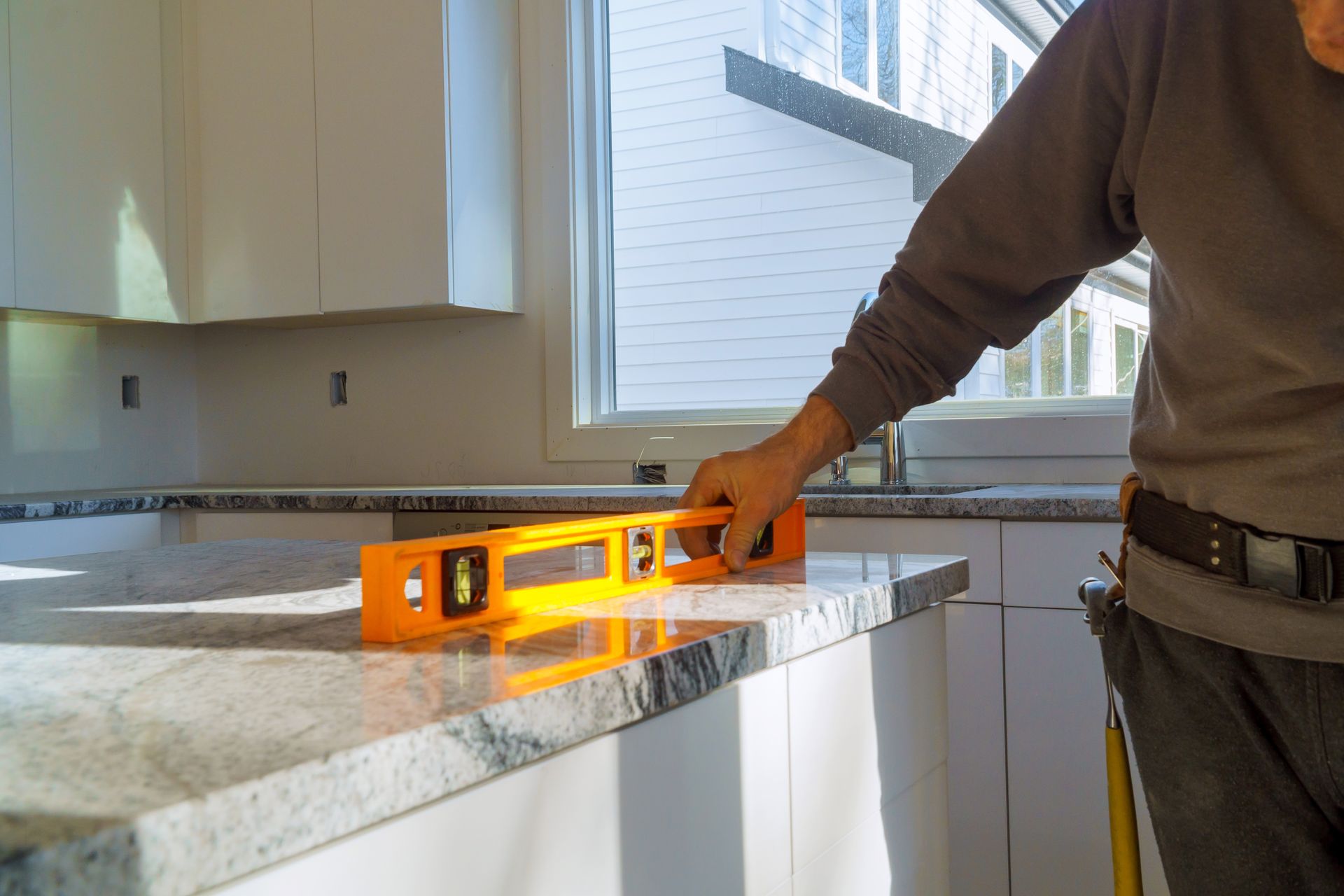 Modern white kitchen with black countertops, under-cabinet lighting, and built-in appliances.