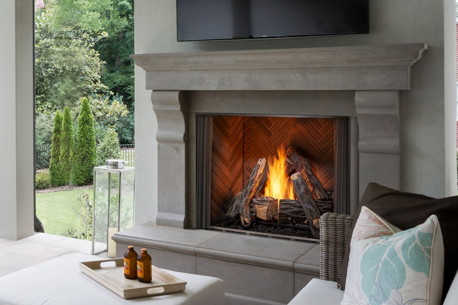 A living room with a fireplace and a television on the wall.