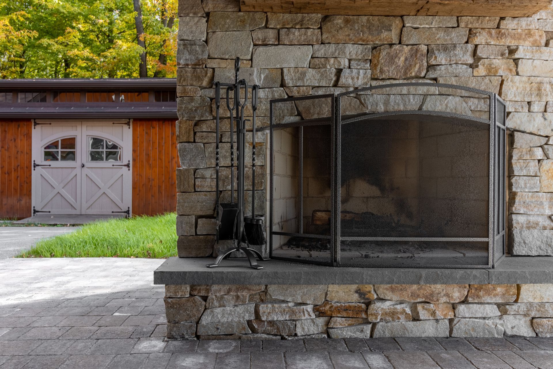 There is a fireplace in the middle of a stone wall.