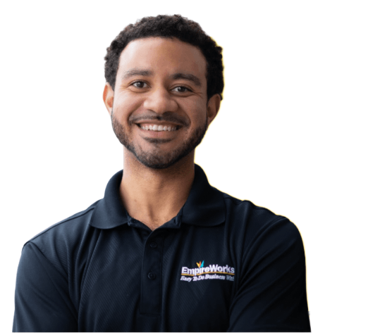 Smiling person wearing a dark blue polo shirt with a logo, set against a white background.