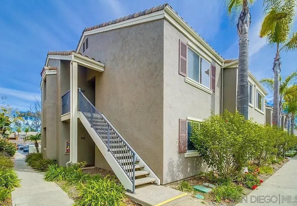 Two-story stucco condo building with exterior stairs