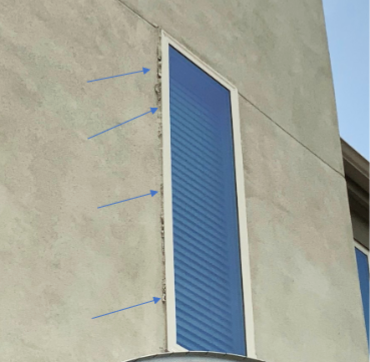 Exterior wall with tall, narrow window. Blue glass within a white frame, arrows indicate areas needing repair.