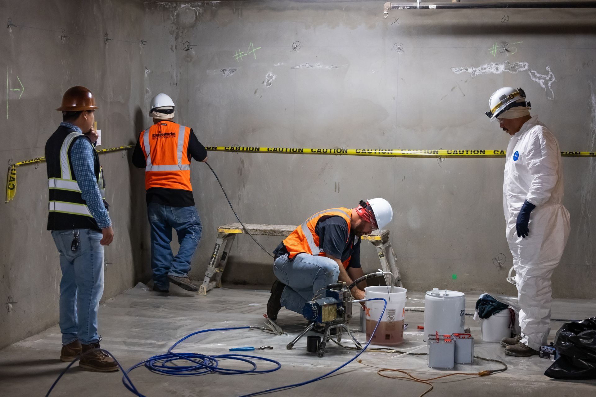 Crew inspecting and repairing concrete walls inside a building