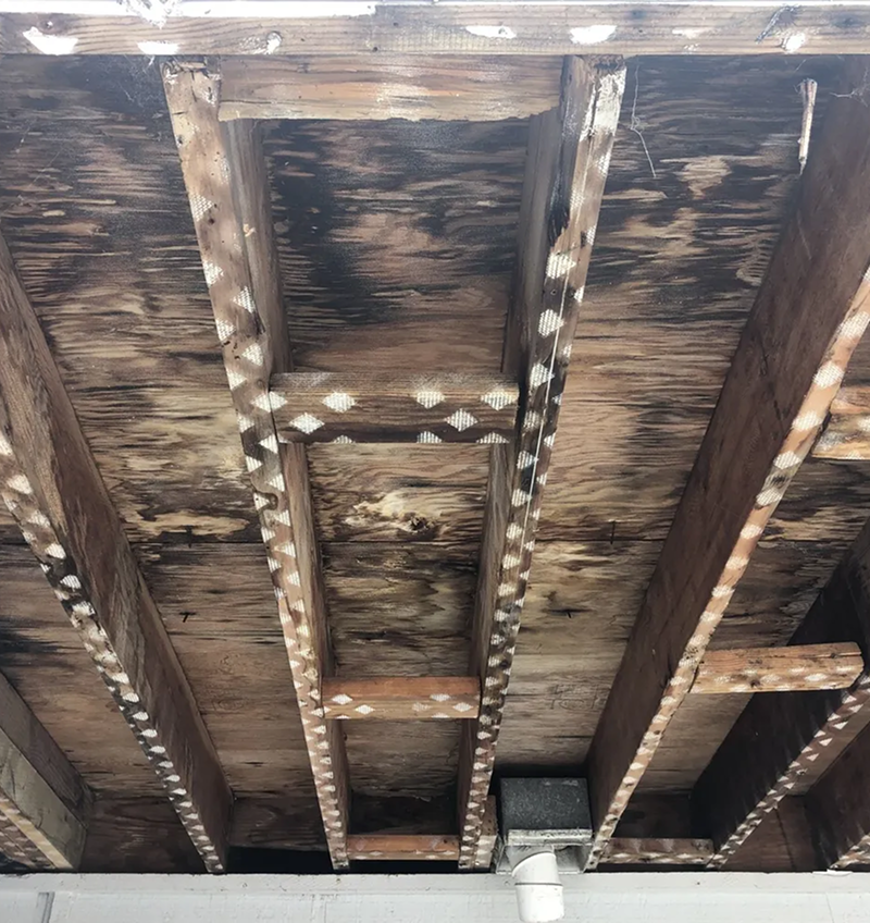 A close up of a wooden ceiling with a lot of beams.