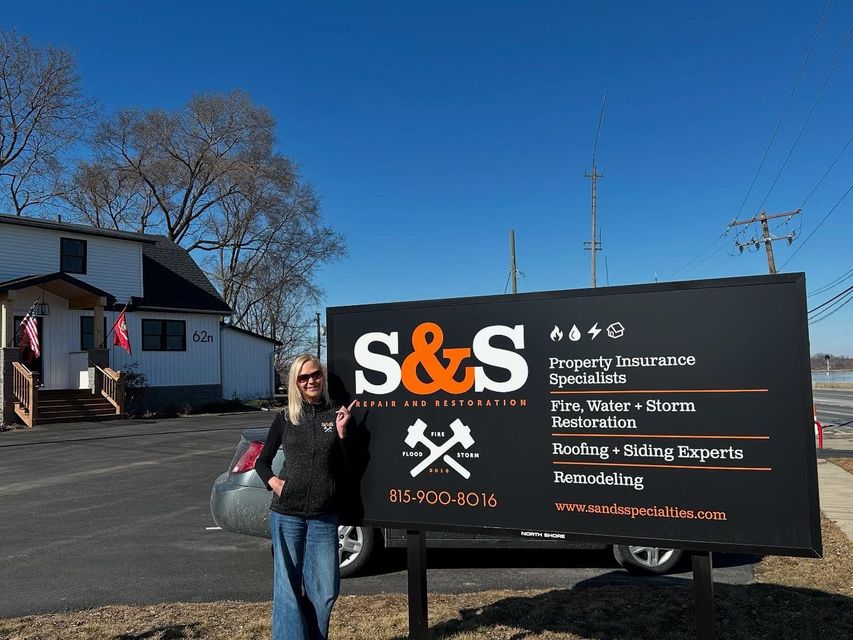 A woman is standing in front of a sign that says s & s