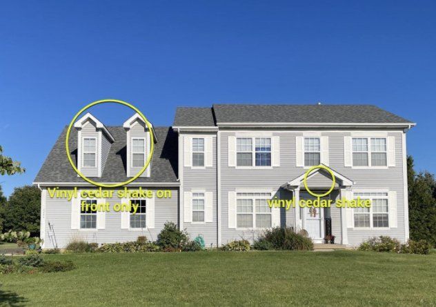 A large house with a gray roof and white shutters