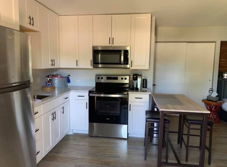 A kitchen with white cabinets and stainless steel appliances.