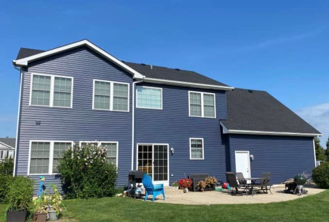 A large blue house with a patio in front of it