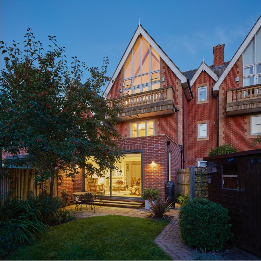 A large red brick house with a shed in front of it