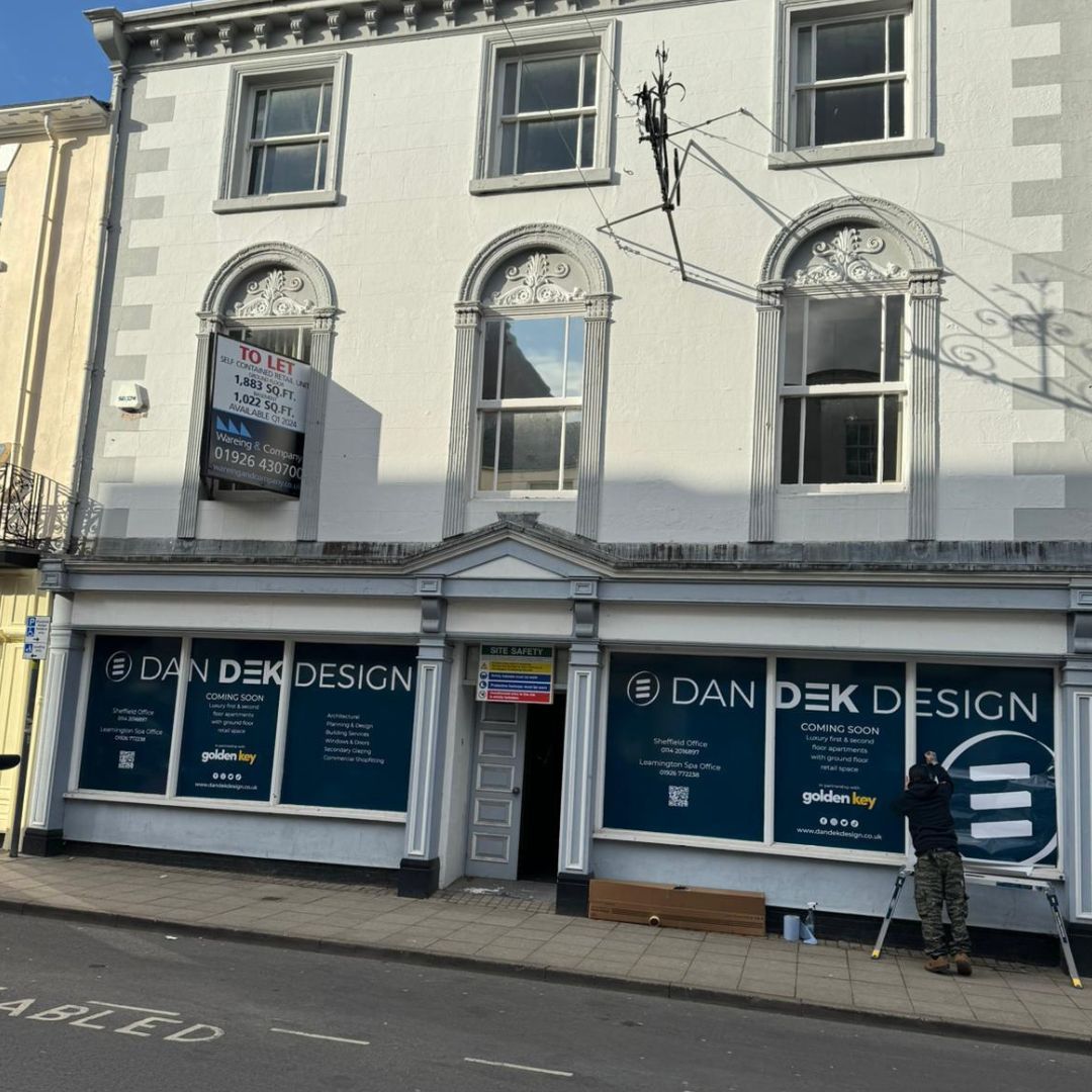 A white building with a sign that says dan dek design