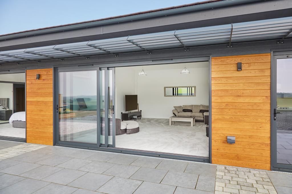 An artist 's impression of a house with sliding glass doors