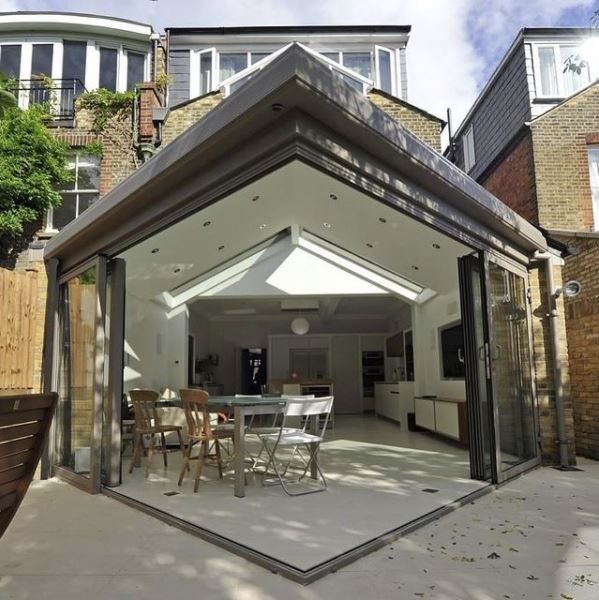 A dining room with a table and chairs in front of a house