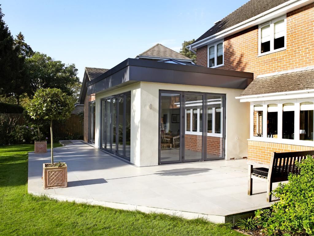 A large house with a patio and a bench in front of it