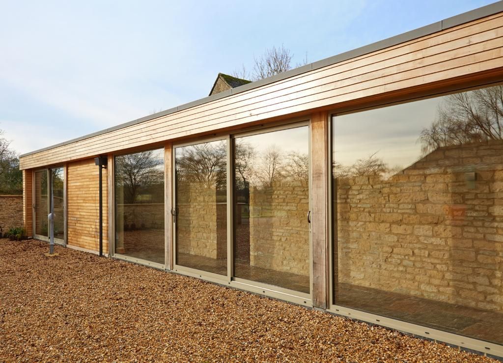 A house with a lot of windows and a lot of gravel in front of it.