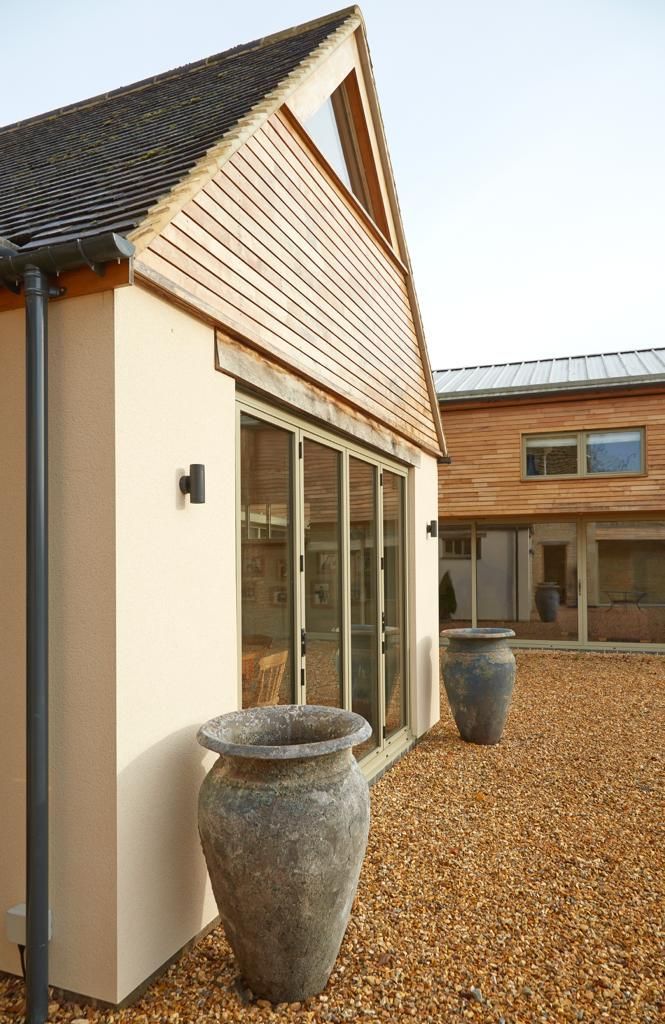 Two large vases are sitting on the side of a house.