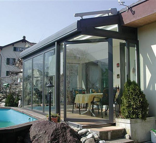 A patio with a table and chairs next to a pool