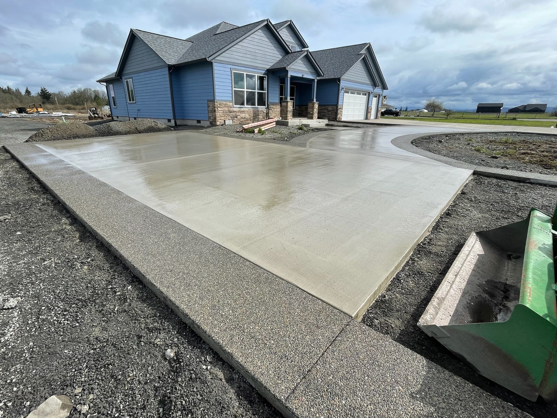 A concrete driveway is being built in front of a house.