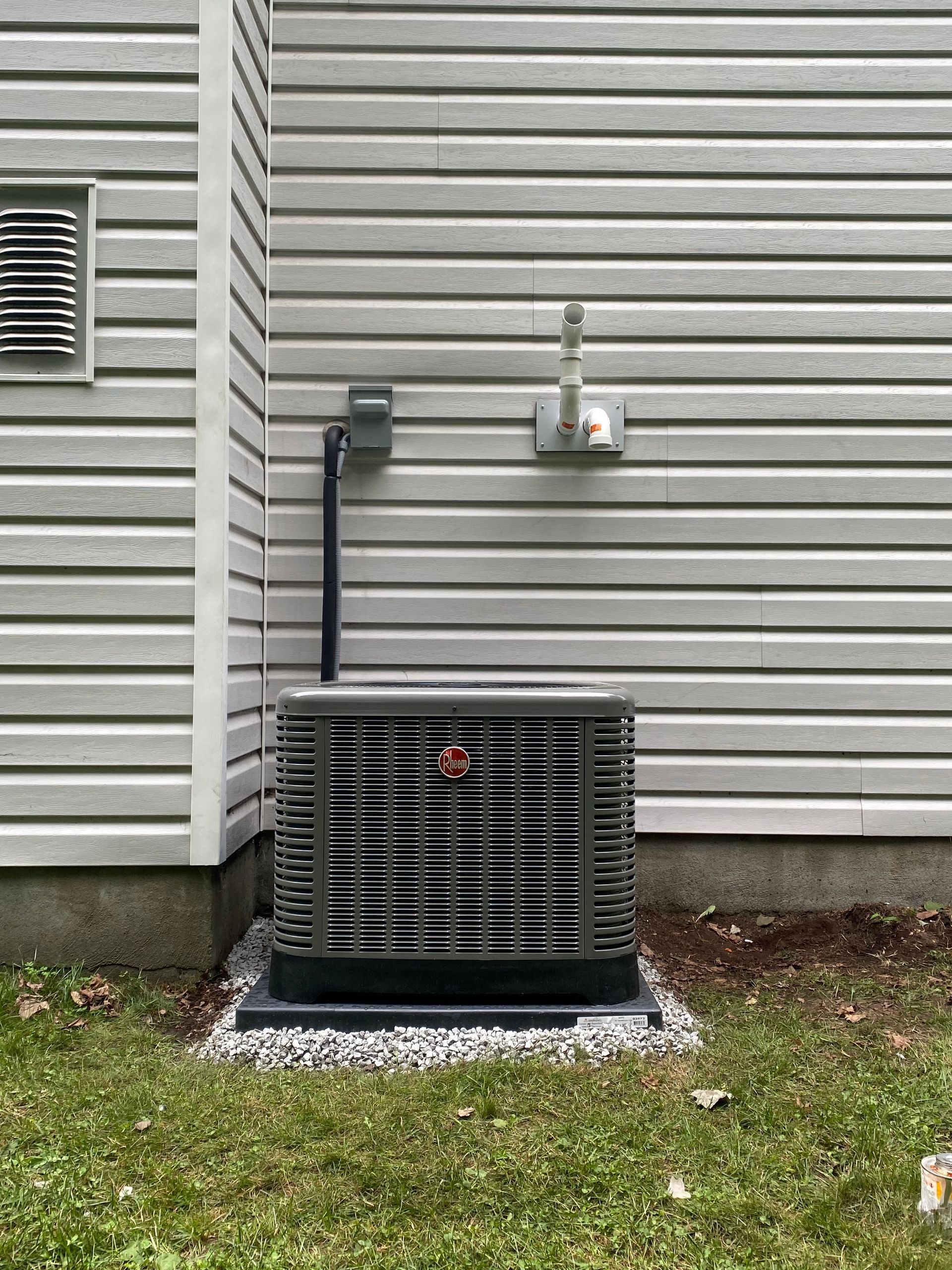 An air conditioner is sitting on the side of a house.