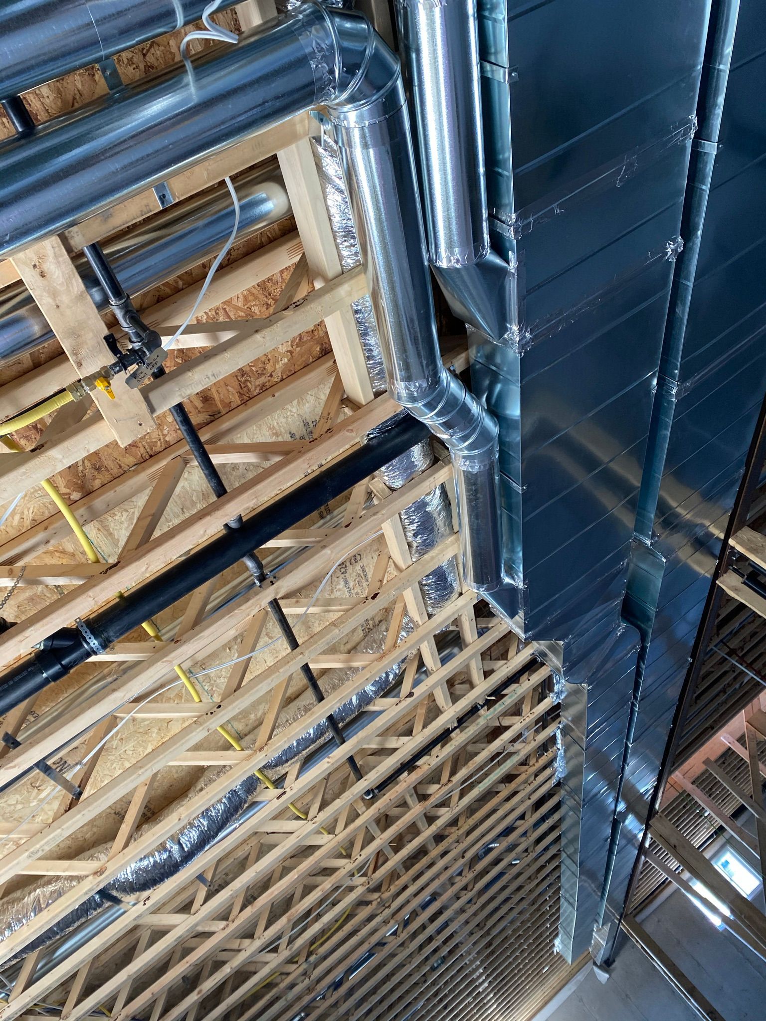 Un bâtiment en construction avec beaucoup de tuyaux sortant du plafond.