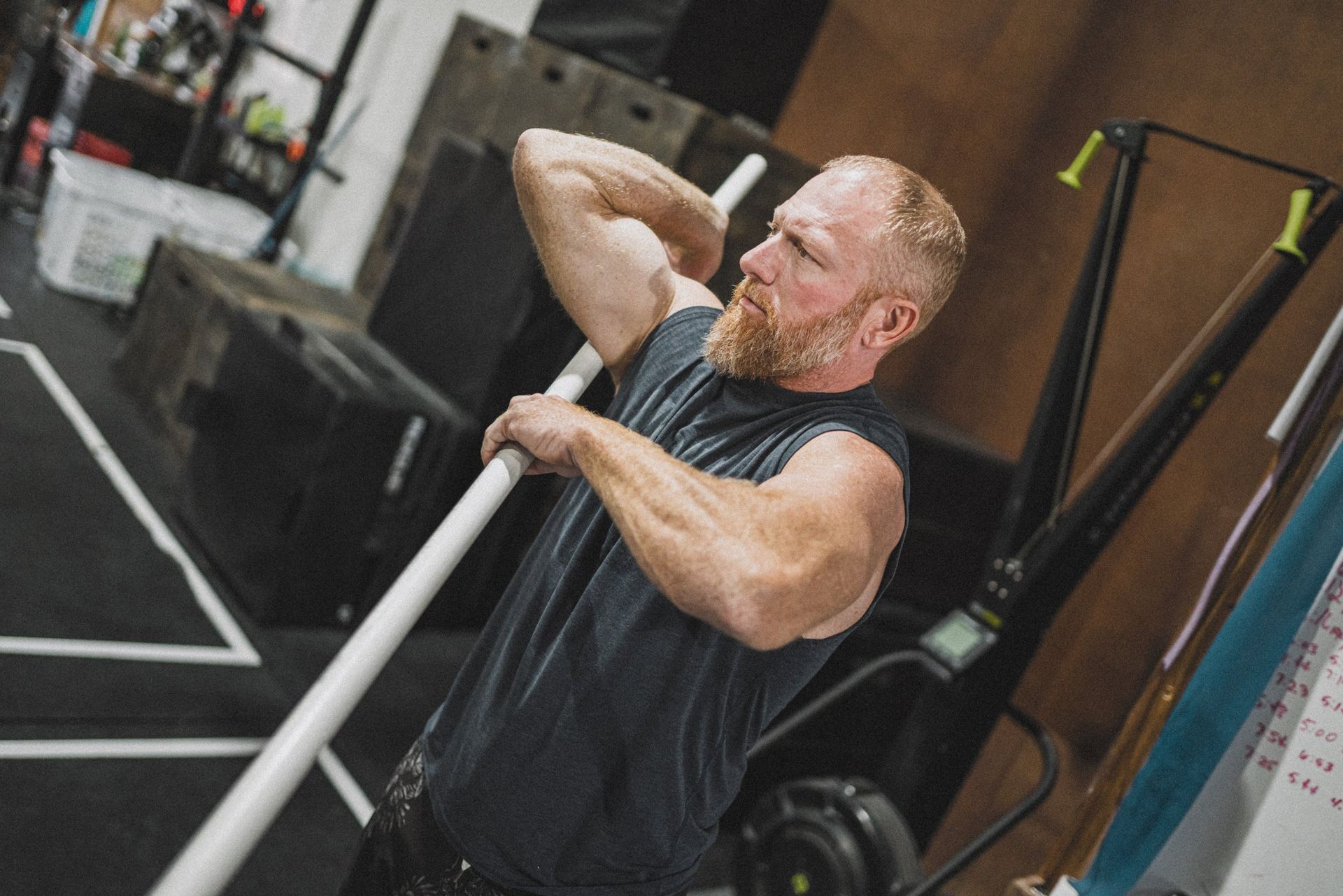 A man is lifting a barbell in a gym.
