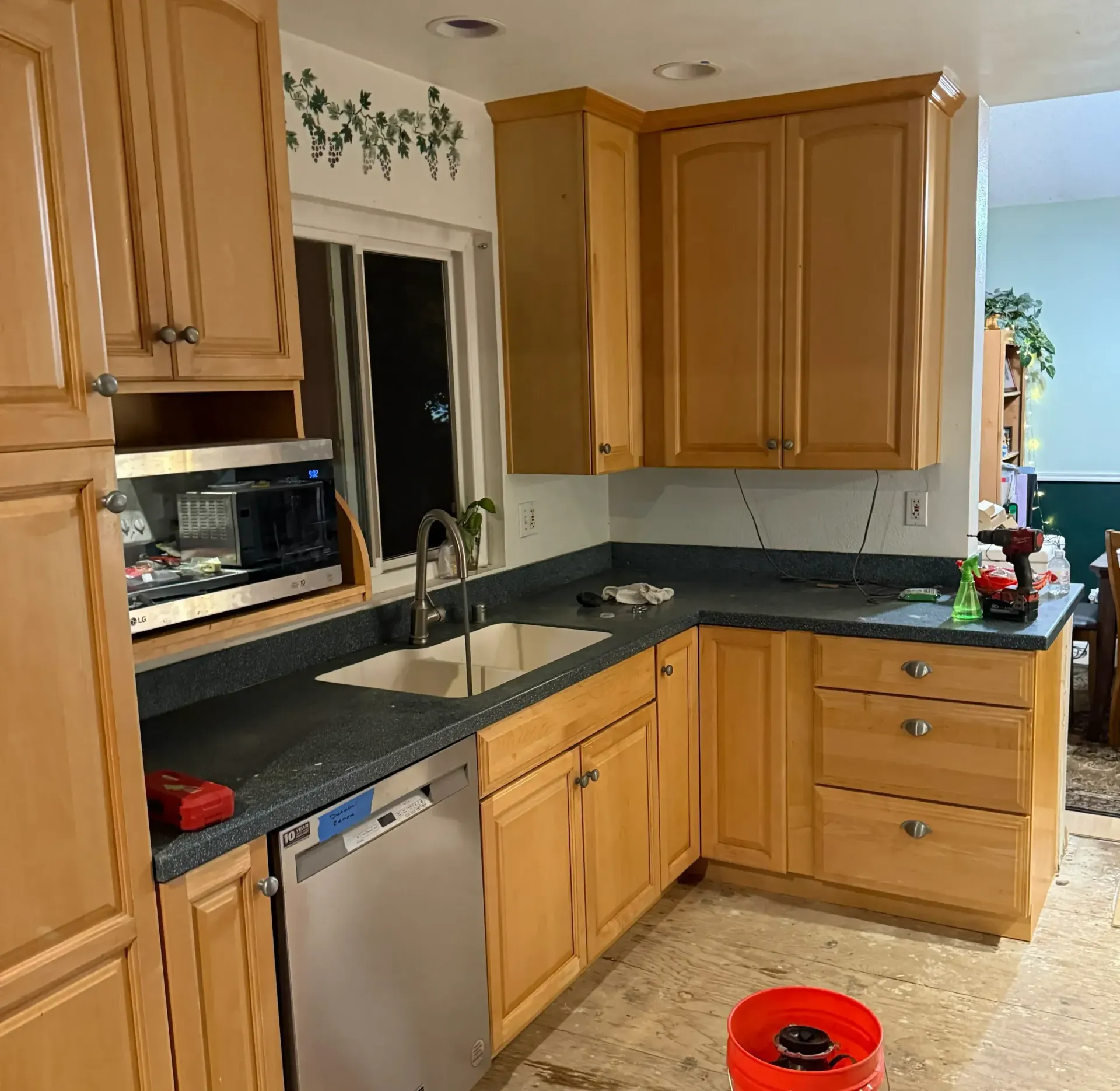 A kitchen with wooden cabinets and a stainless steel dishwasher