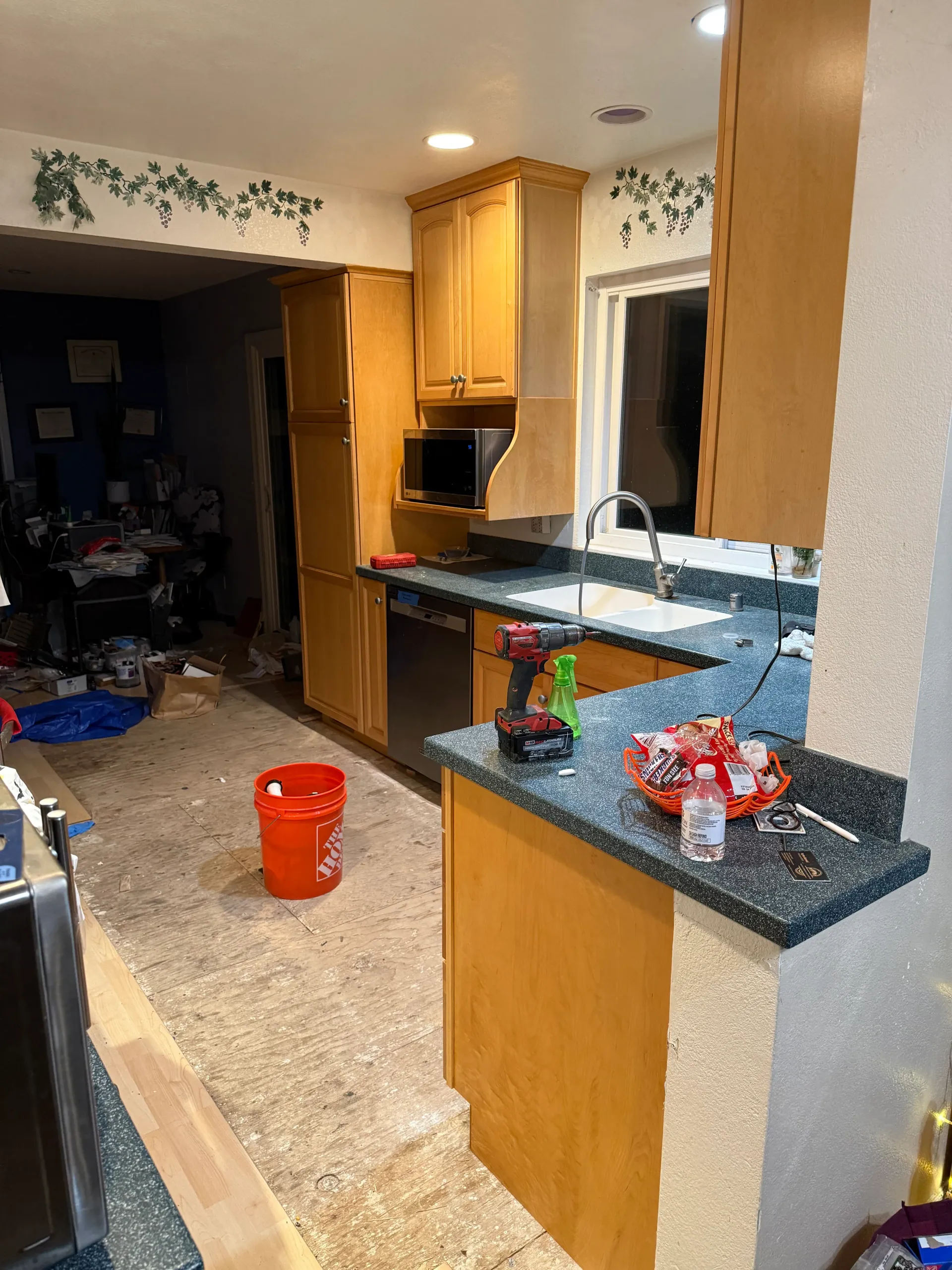 A kitchen with wooden cabinets and granite counter tops is being remodeled.
