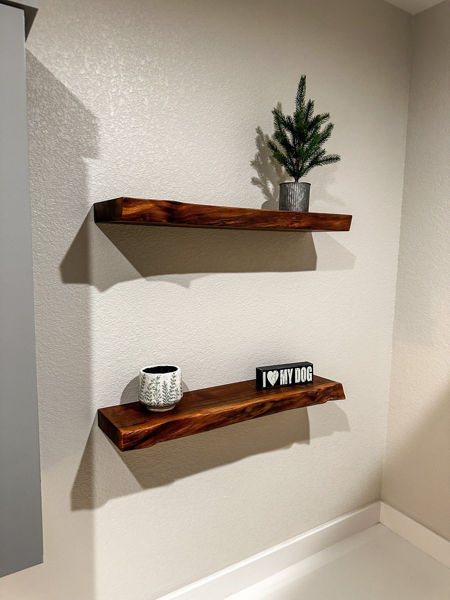 Two wooden shelves are hanging on a wall in a room.