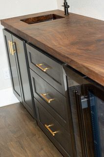 Dark wood bathroom vanity with brass handles and a built-in sink countertop