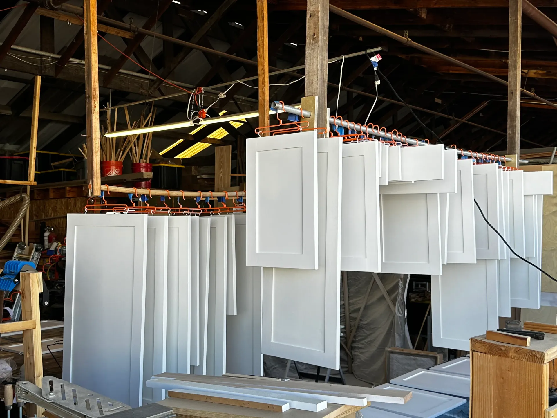A bunch of white cabinets are hanging from the ceiling