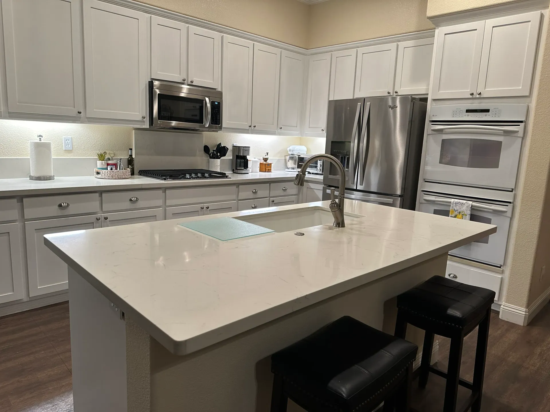A kitchen with white cabinets and stainless steel appliances