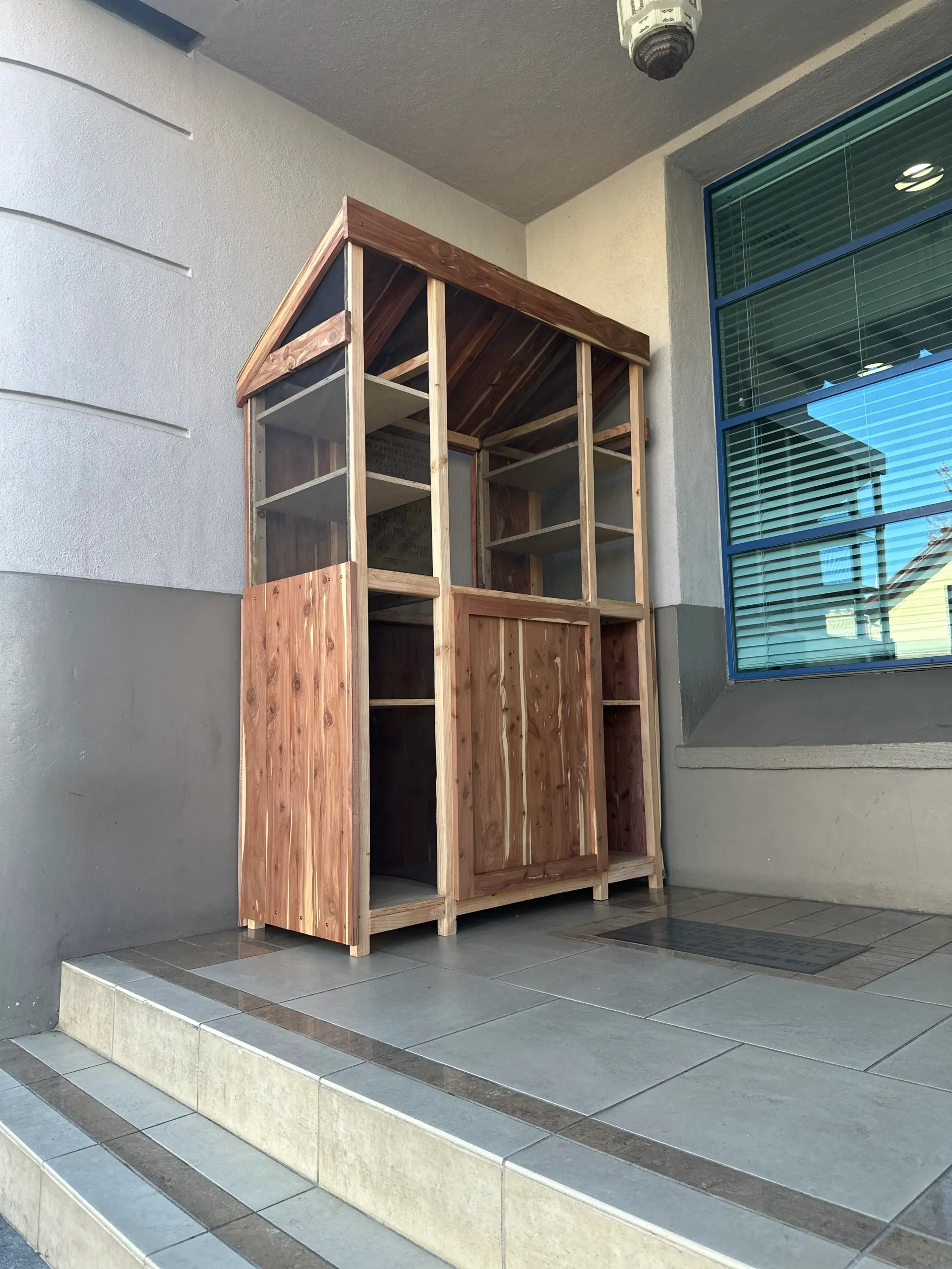 A wooden shed is sitting on the steps of a building.
