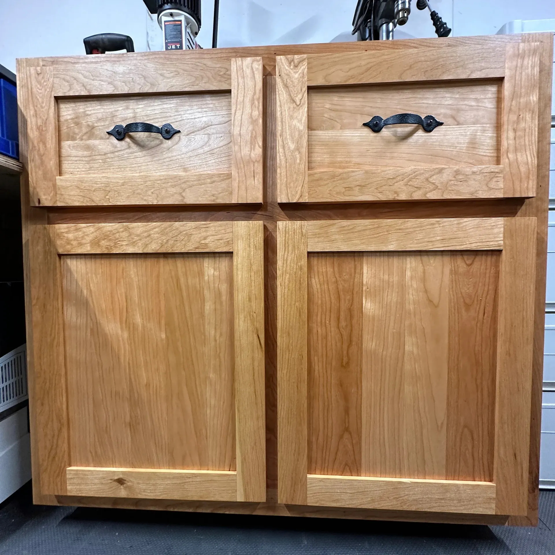 A wooden cabinet with two drawers and two doors in a room.