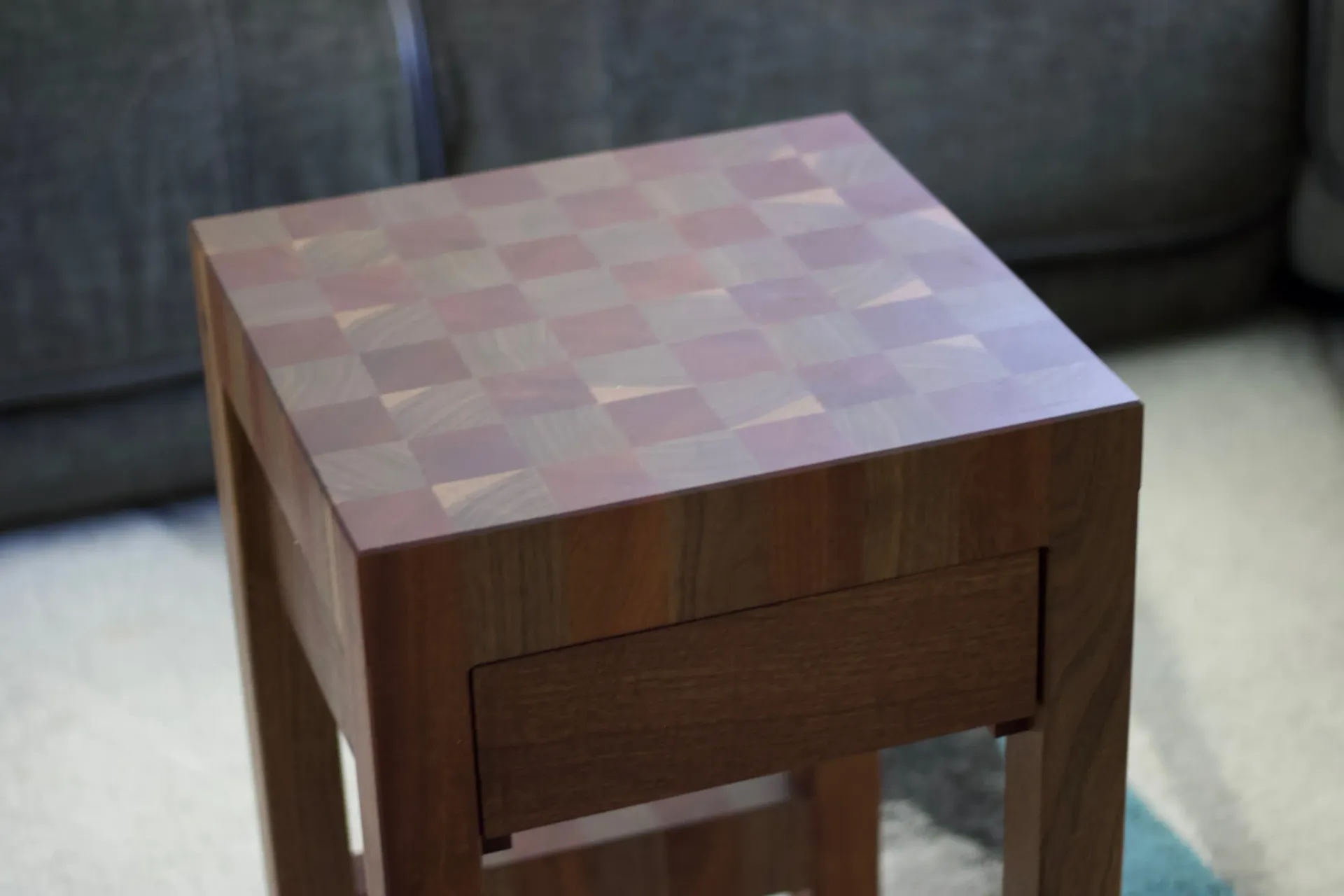 A small wooden table with a drawer underneath it