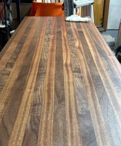 Wooden tabletop with a striped grain pattern in a workshop or garage setting