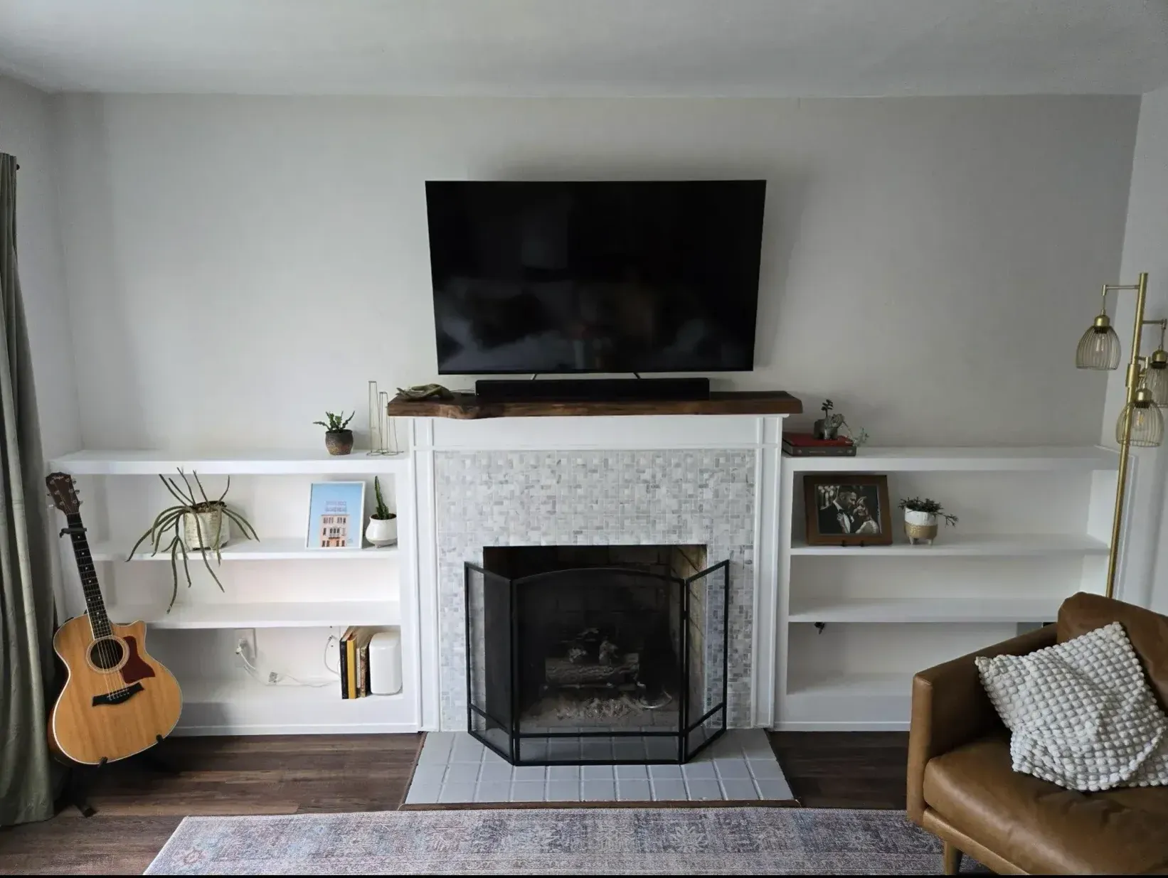 A living room with a fireplace and a flat screen tv.