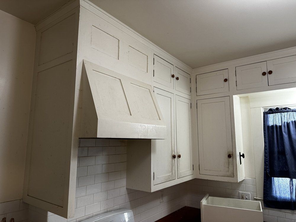 A kitchen with white cabinets and a sink