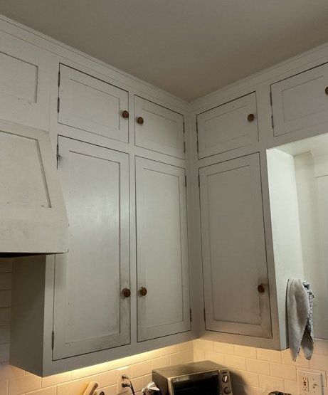 A kitchen with white cabinets and a microwave