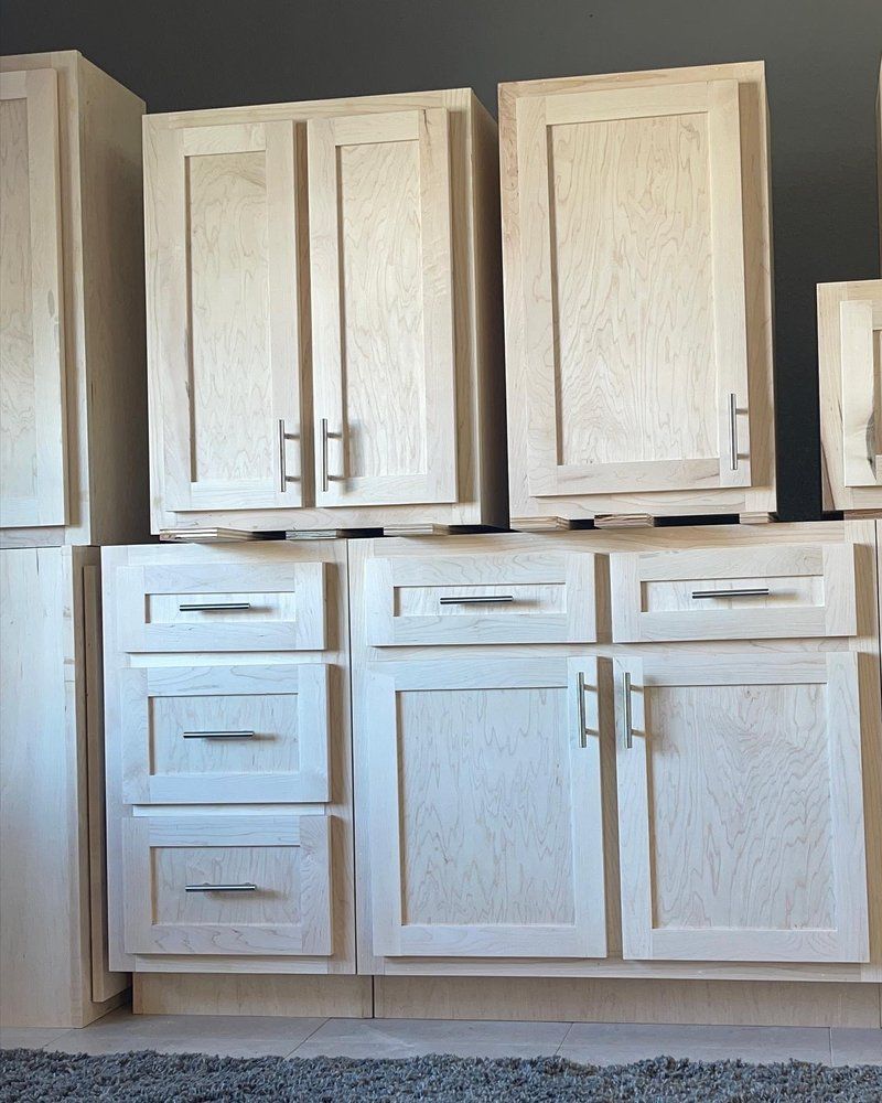 A row of white cabinets with drawers and doors