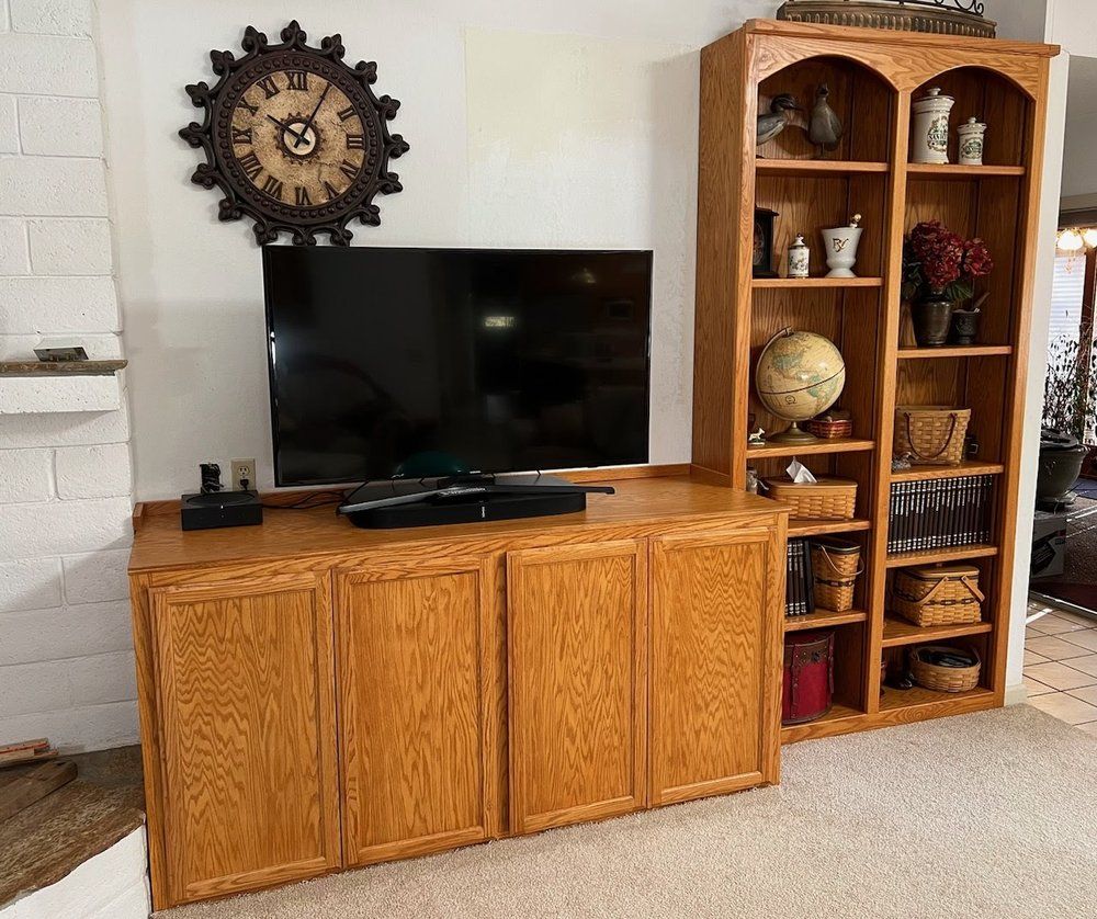 A living room with a clock on the wall above the television