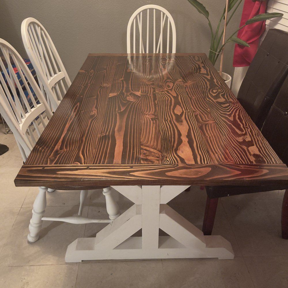 A wooden table with white chairs in a dining room