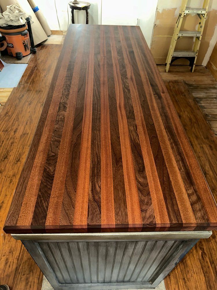 A wooden table with a ladder in the background is sitting on a wooden floor.