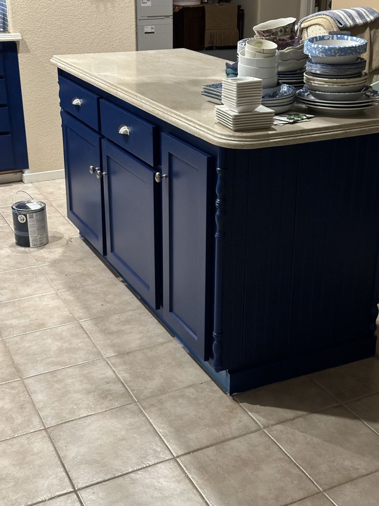 A kitchen with blue cabinets and a white counter top