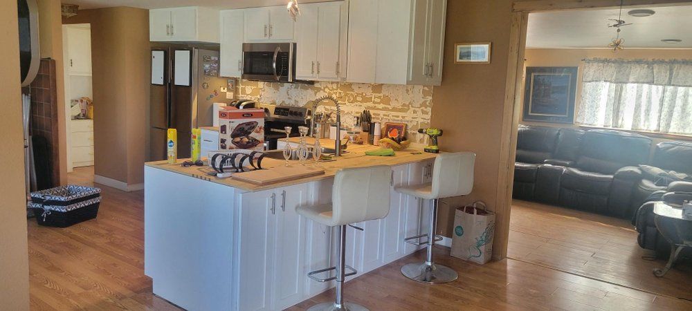 A kitchen with a large island and stools in a house.