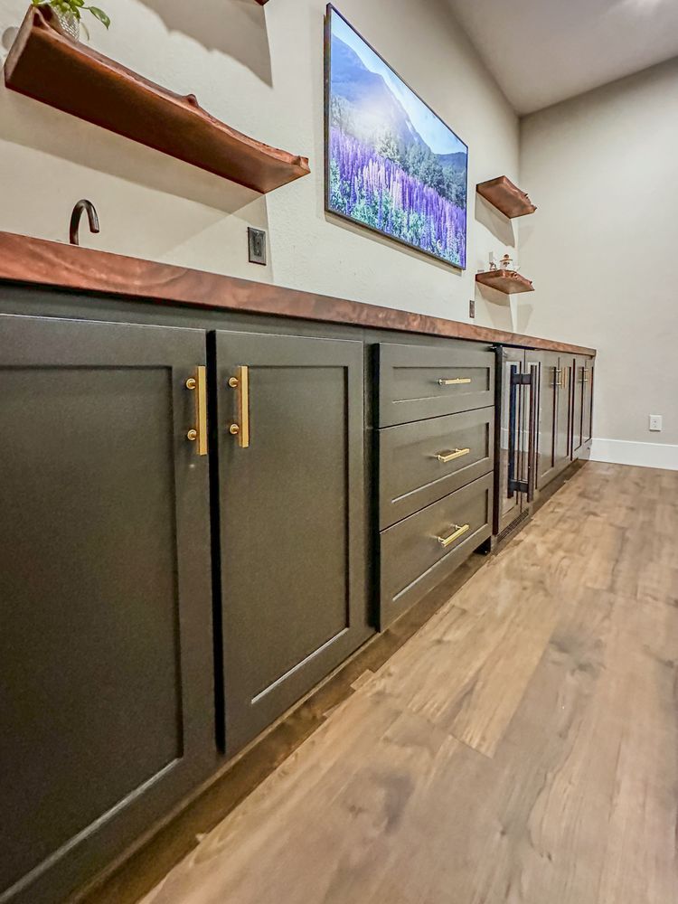 A kitchen with a large flat screen tv on the wall above the counter.