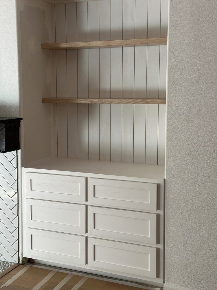 A white cabinet with drawers and shelves in a room