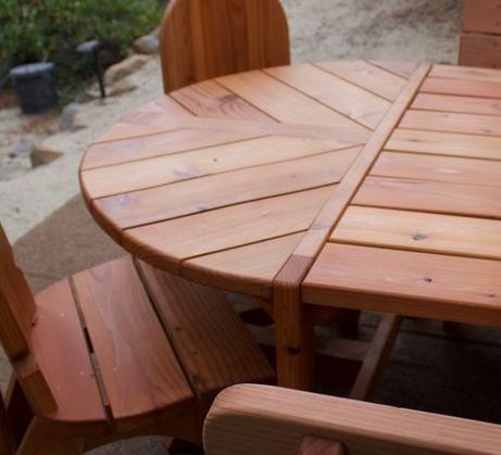A wooden table with a round top and two chairs