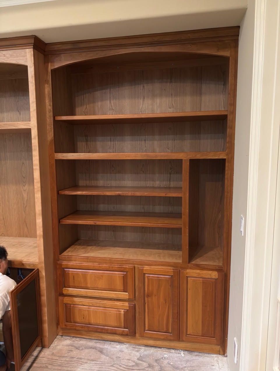 Built-in wooden bookshelves with cabinets and shelves in a home interior.