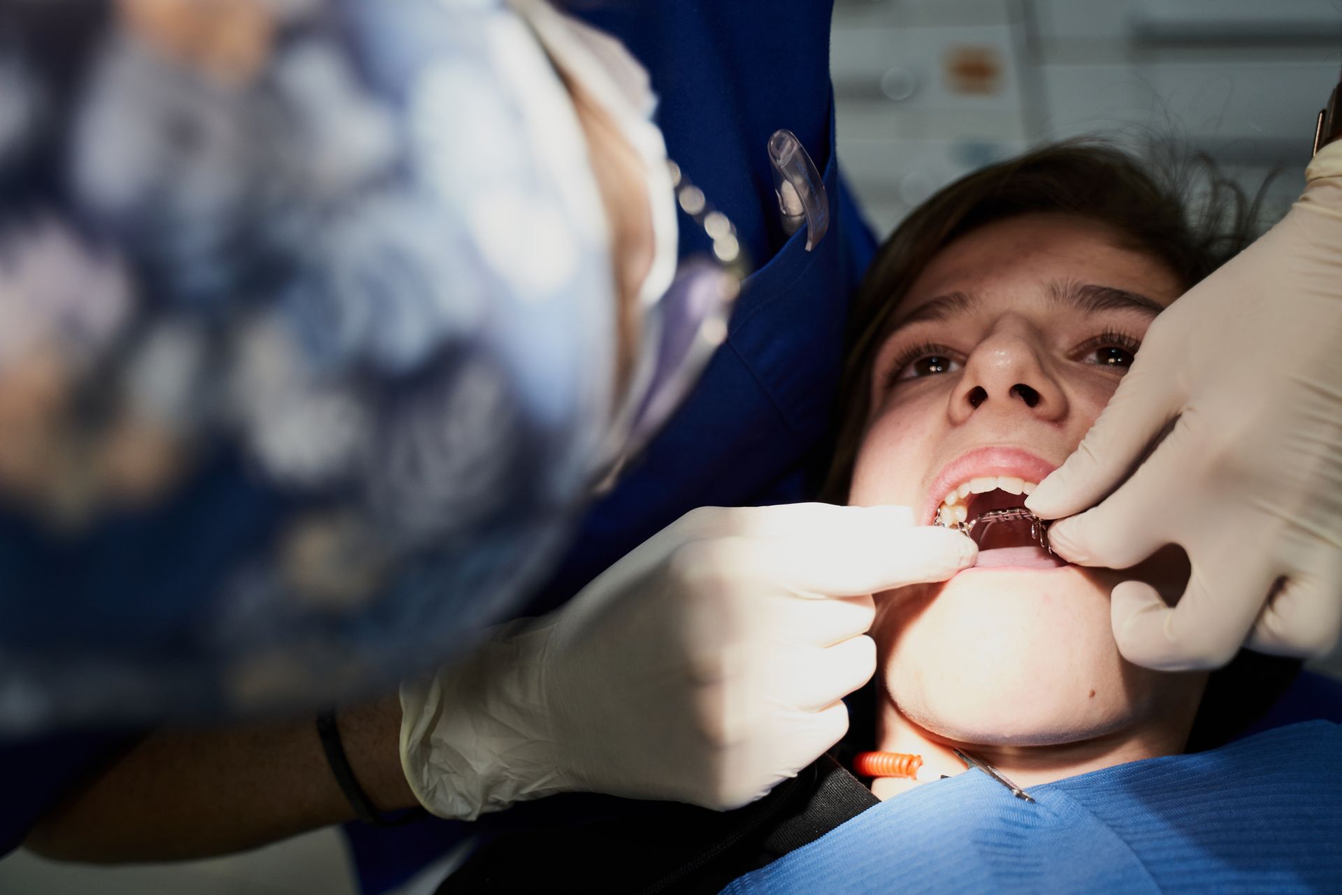 A close up of a person getting their teeth examined by a dentist.
