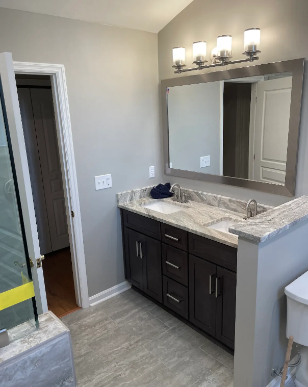 A bathroom with two sinks and a large mirror.